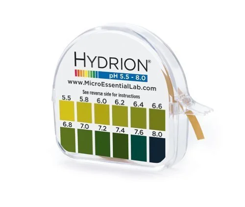 A small transparent container with a pH color chart for Hydrion test strips, showing pH levels from 5.5 to 8.0 filled with corresponding colored sections.