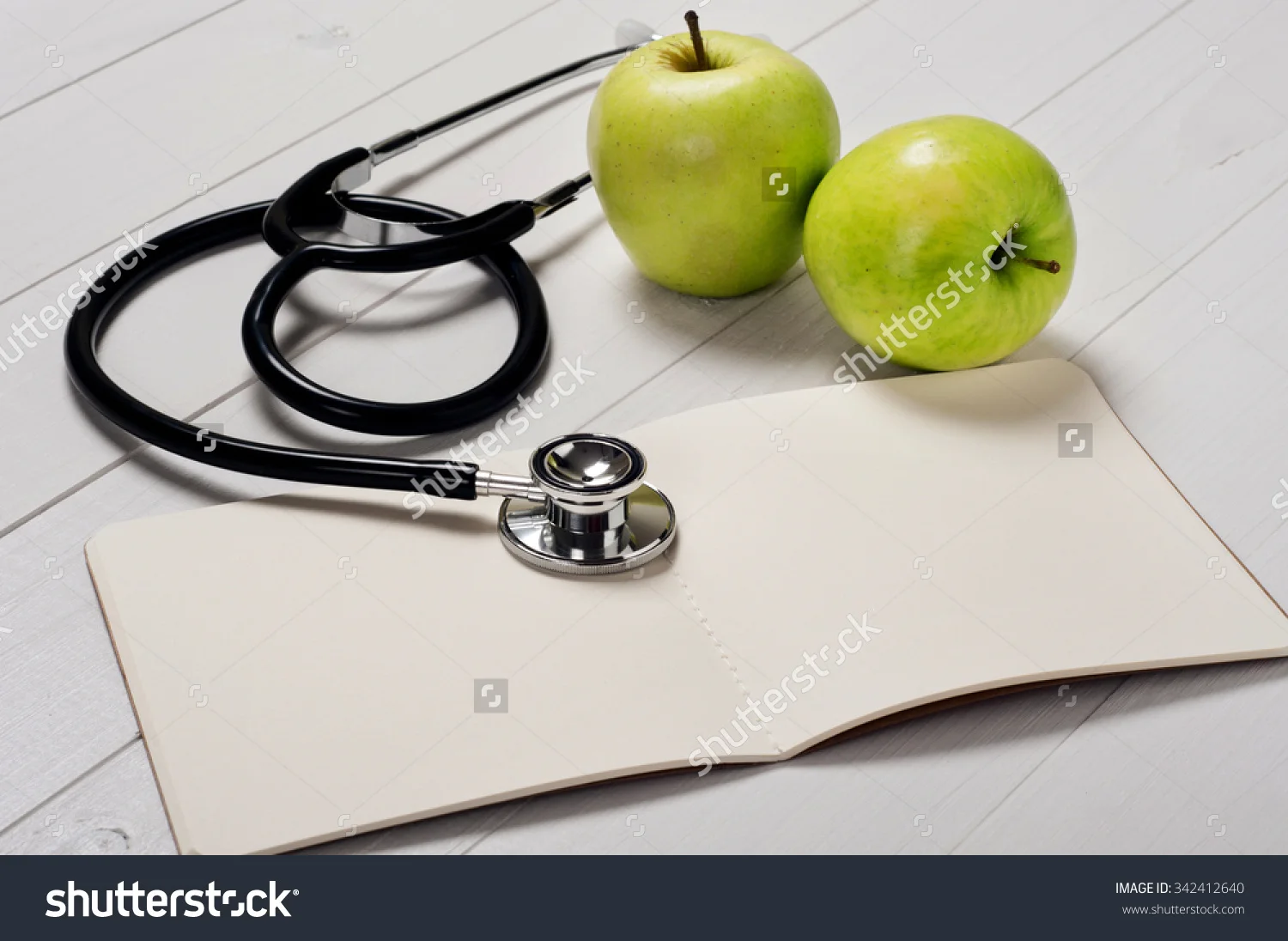 stock-photo-open-notebook-with-a-stethoscope-and-apple-on-a-white-background-closeup-342412640.jpg