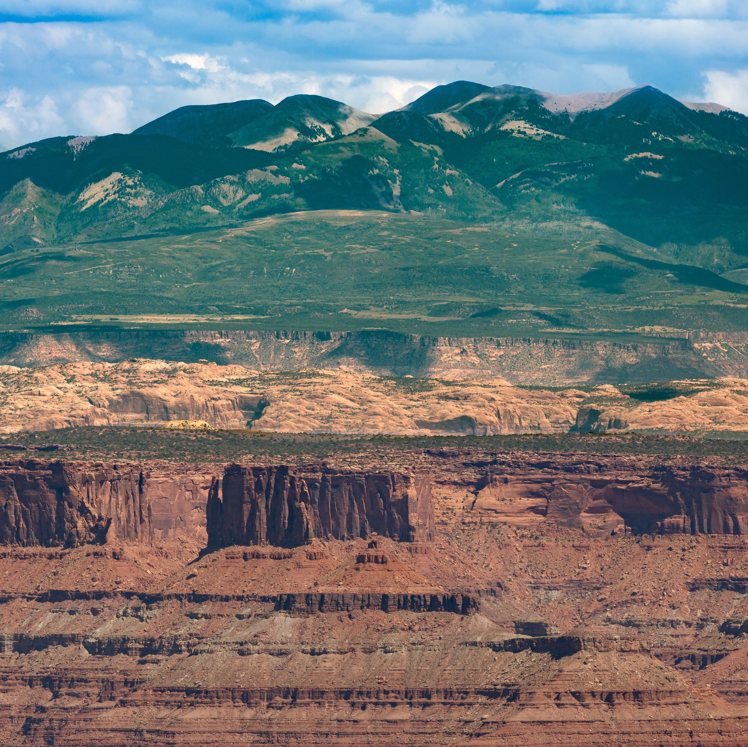 The La Sal Mountains stand 33 miles from Island in the Sky, Canyonlands National Park. From this vantage point across great distance you can see two extremes of geology: deep canyons and tall mountains.