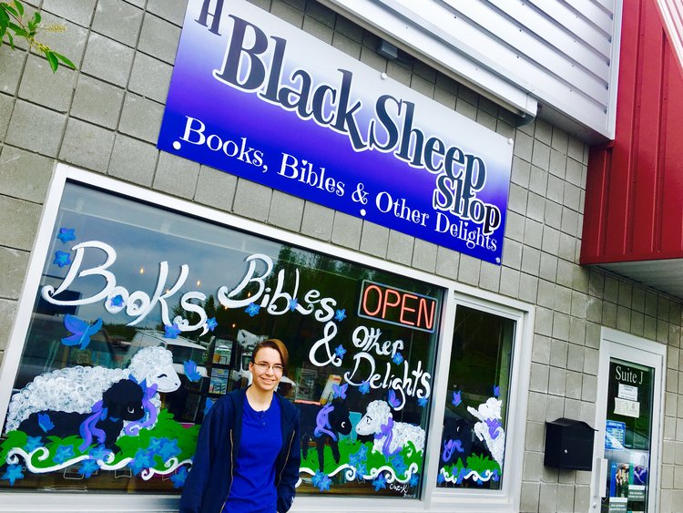 Kacey of Craz-K Designs stands with her window art outside of A Black Sheep Shop in Wasilla. 