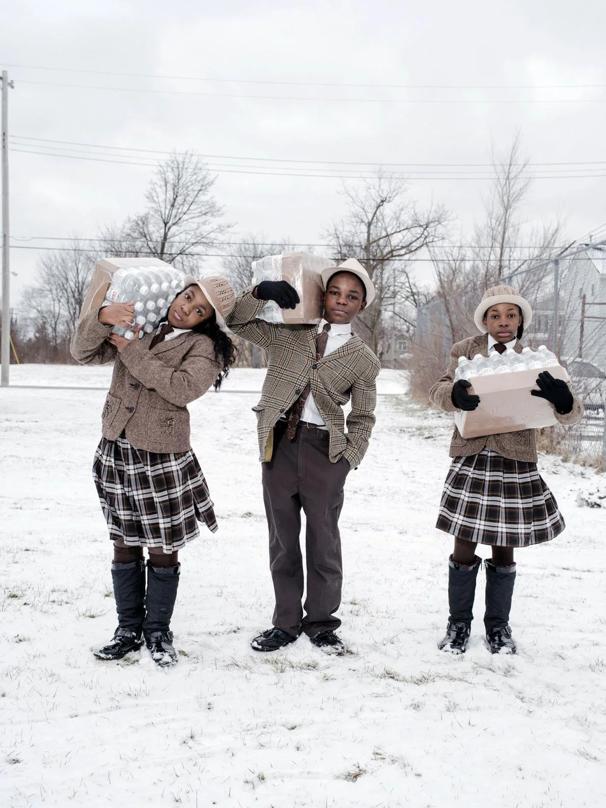 In Flint, Michigan, siblings Julie, Antonio, and India Abram collect their daily allowance of bottled water from Fire Station #3, their local water resource site; photo: Wayne Lawrence