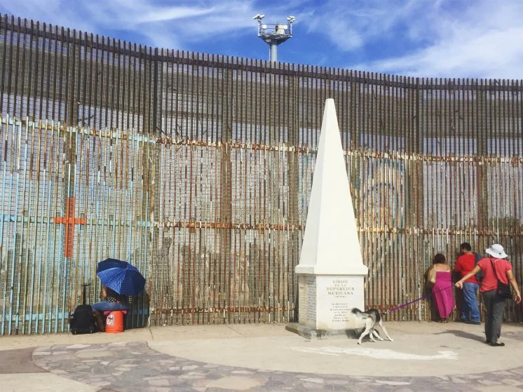 People connecting with their loved ones through the border fence in Tijuana on the U.S.-Mexico border by the last border monument under the U.S. surveillance cameras. photo: Karoliina Paatos