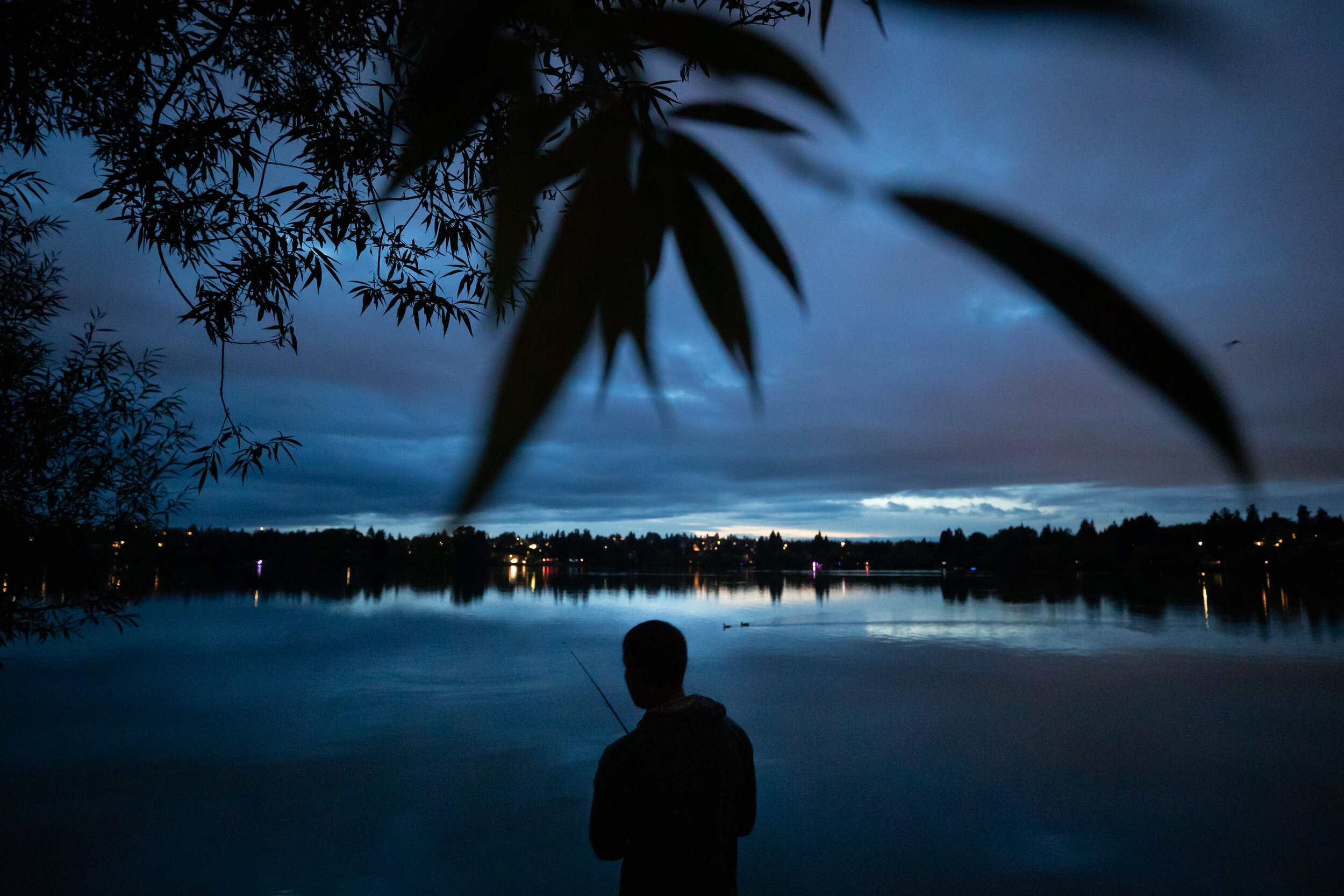  Will Fredo fishes alongside the lake during the annual Luminata festival Saturday in Green Lake Park in Seattle  on Sept. 21, 2019. 