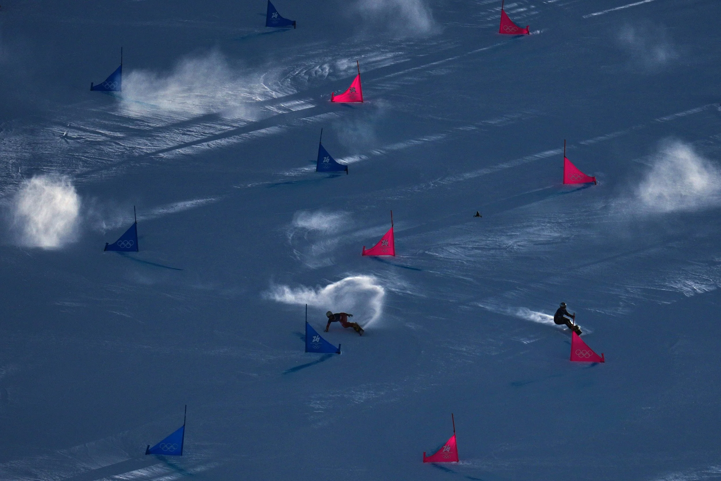  Switzerland's Ladina Caviezel, left, and Ukraine's Annamari Dancha compete during the women's snowboarding parallel giant slalom qualifications at the 2026 Winter Olympics, in Livigno, Italy, Sunday, Feb. 8, 2026. (AP Photo/Abbie Parr) 