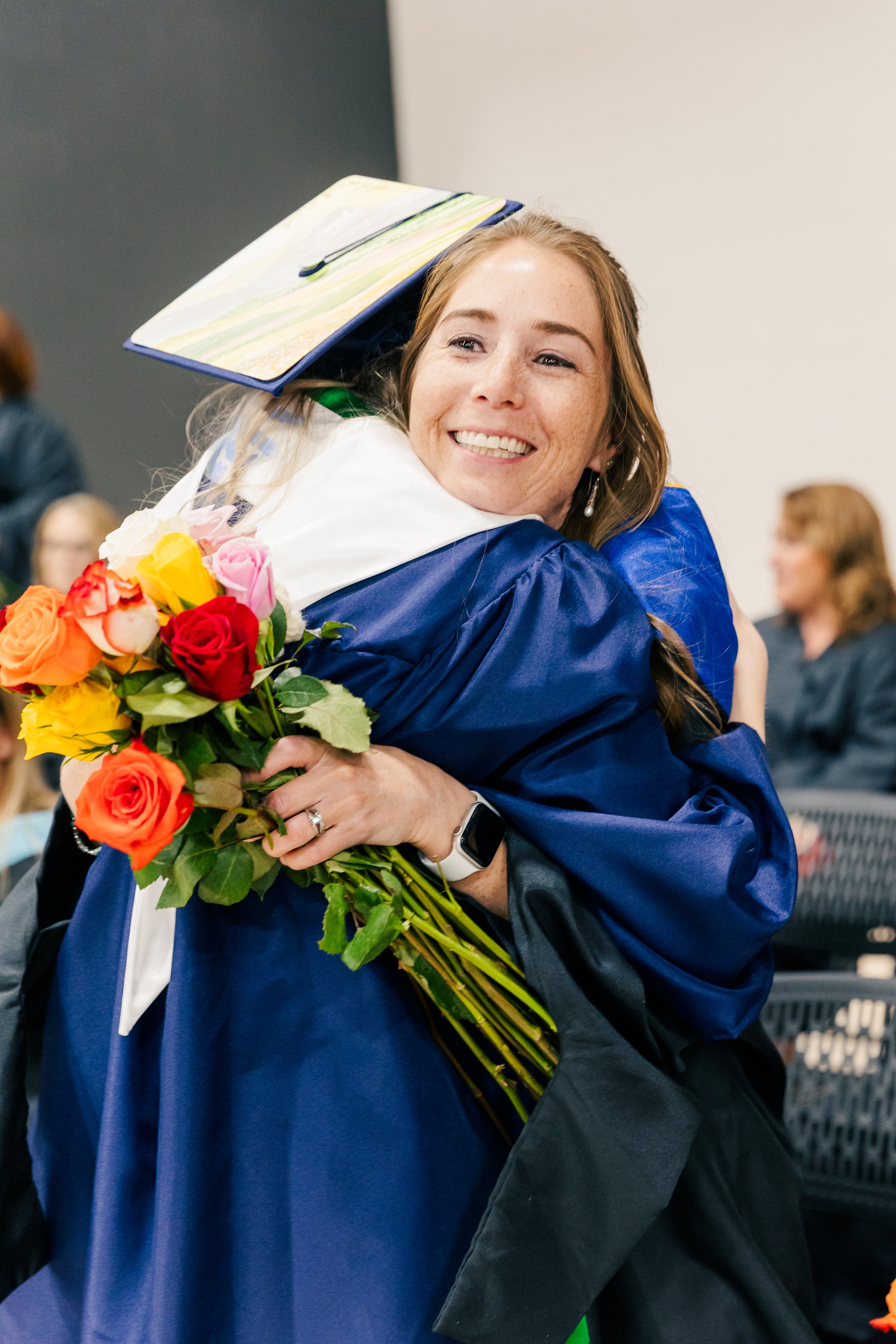 A teacher hugging a graduate