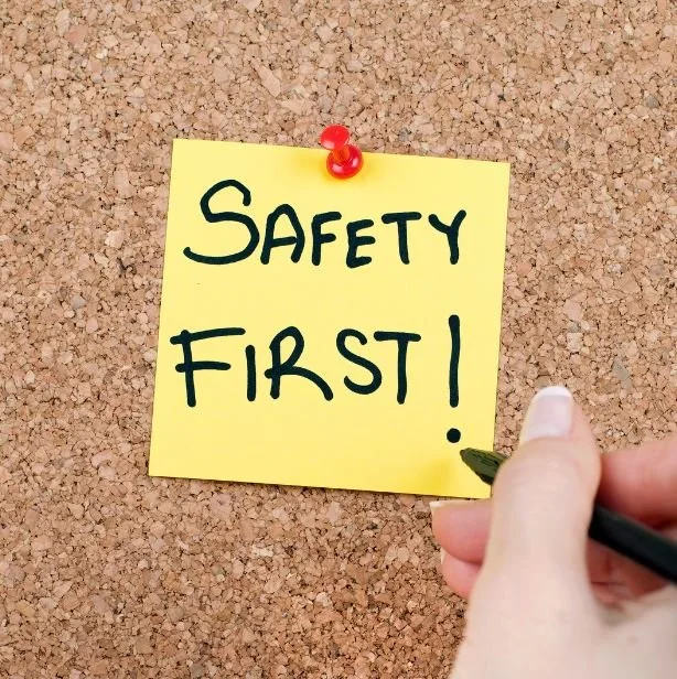 A Post-It note that says "Safety First" on it, tacked to a cork board
