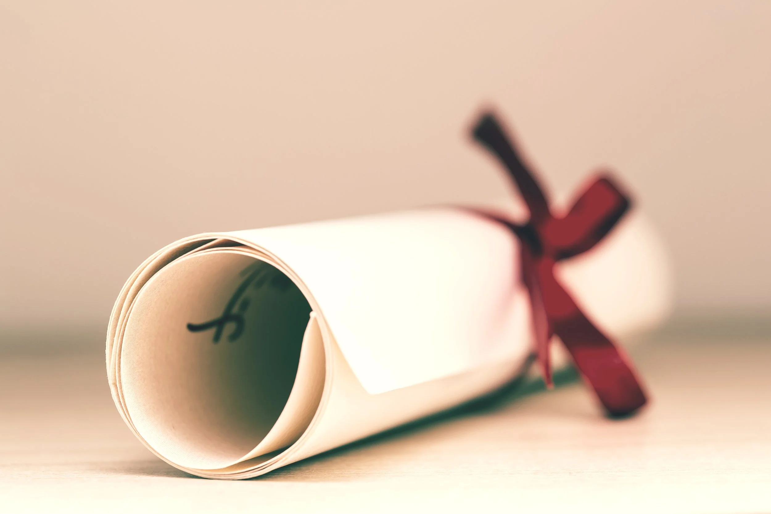 A certificate rolled up and tied with a red bow