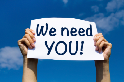 We need you! sign held up by a person