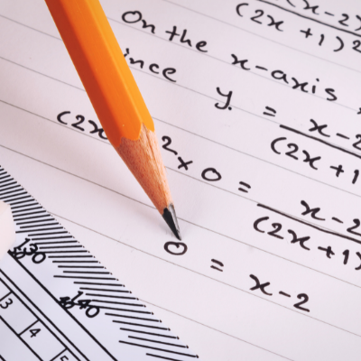 A close up of a math worksheet with a pencil and a ruler