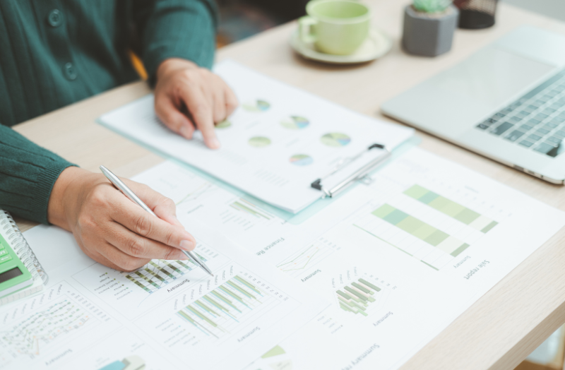 Person sitting at a desk looking at graphs and charts