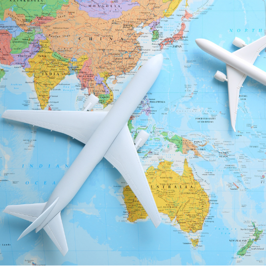 Two plastic airplanes on top of a world map
