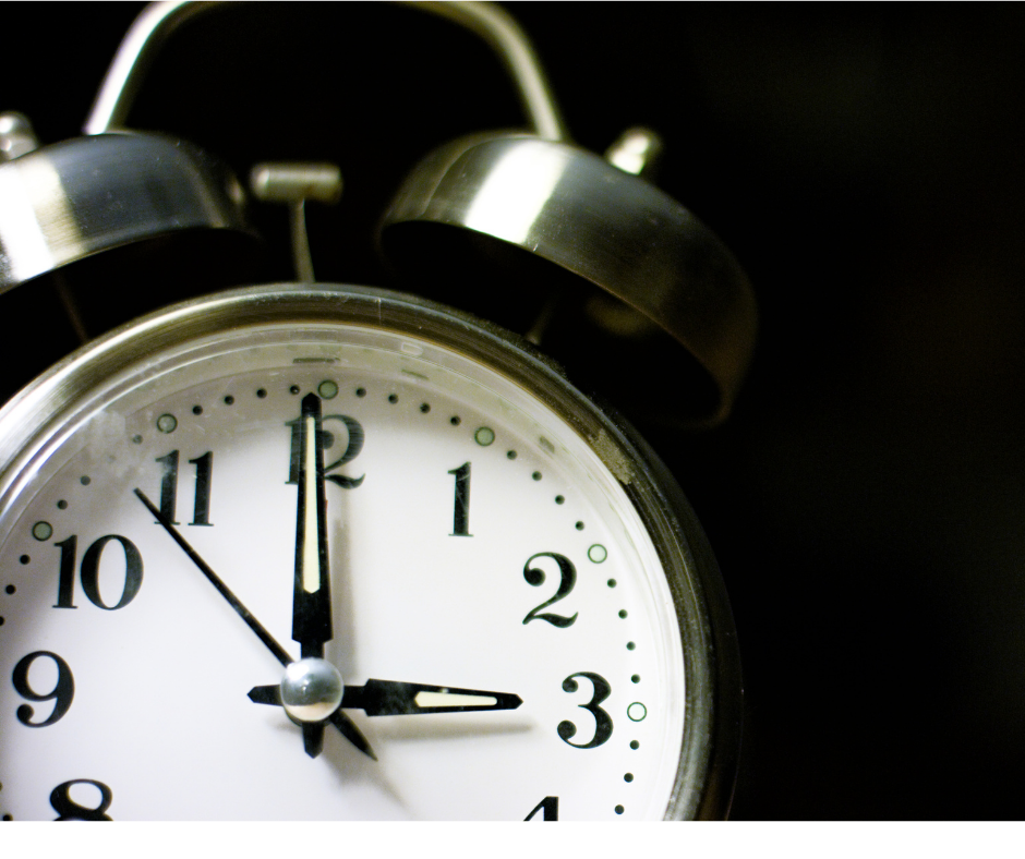 An old black and white clock, with a black background