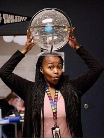 Photo of Mrs. Davis with a clear globe of the solar system above her head