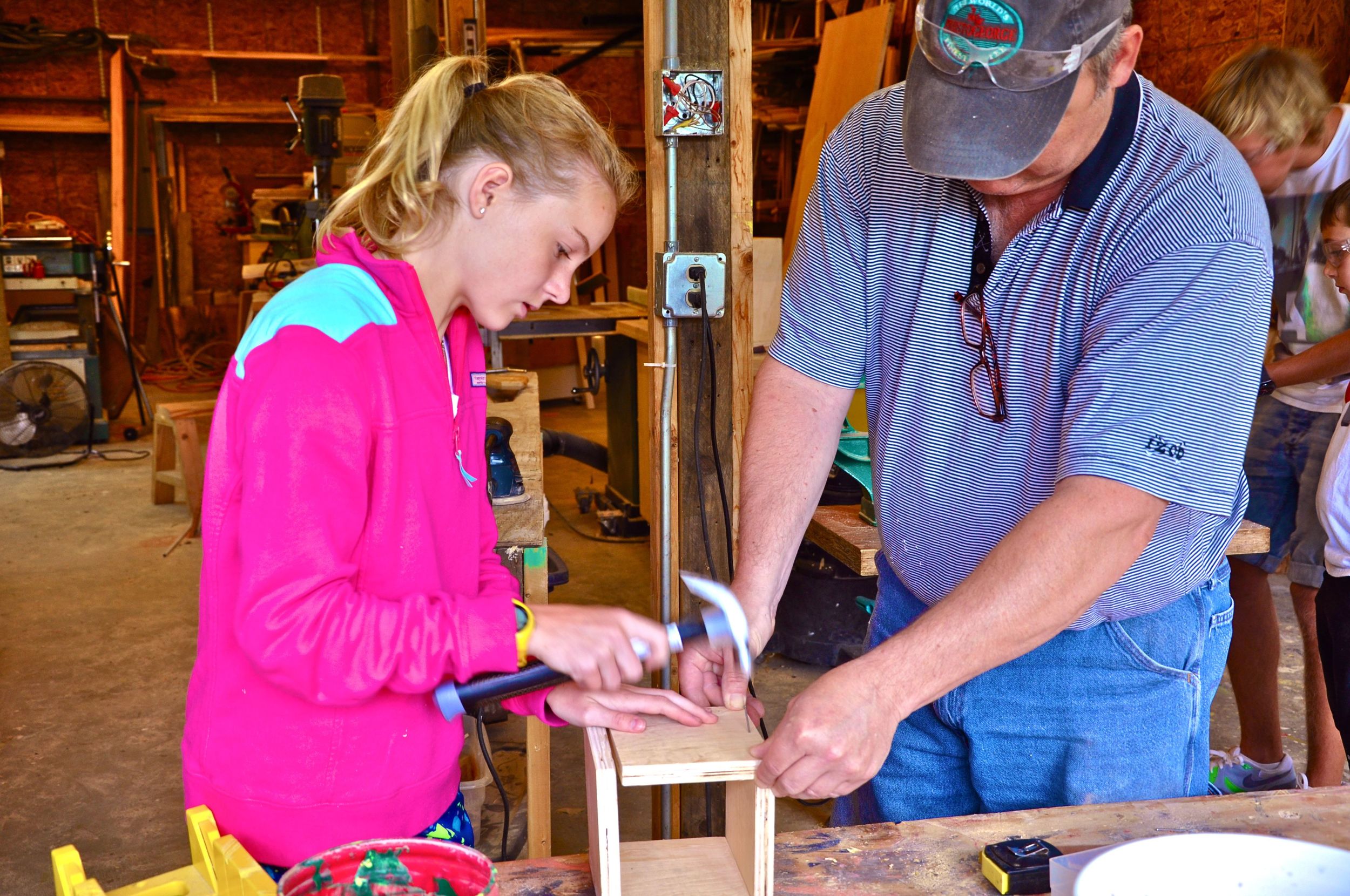 tessa-hammers-a-nail-into-her-project-while-mark-holds-the-boards-steady.jpg