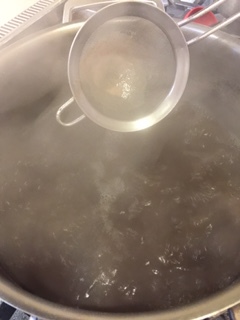 Skimming foam off surface.
