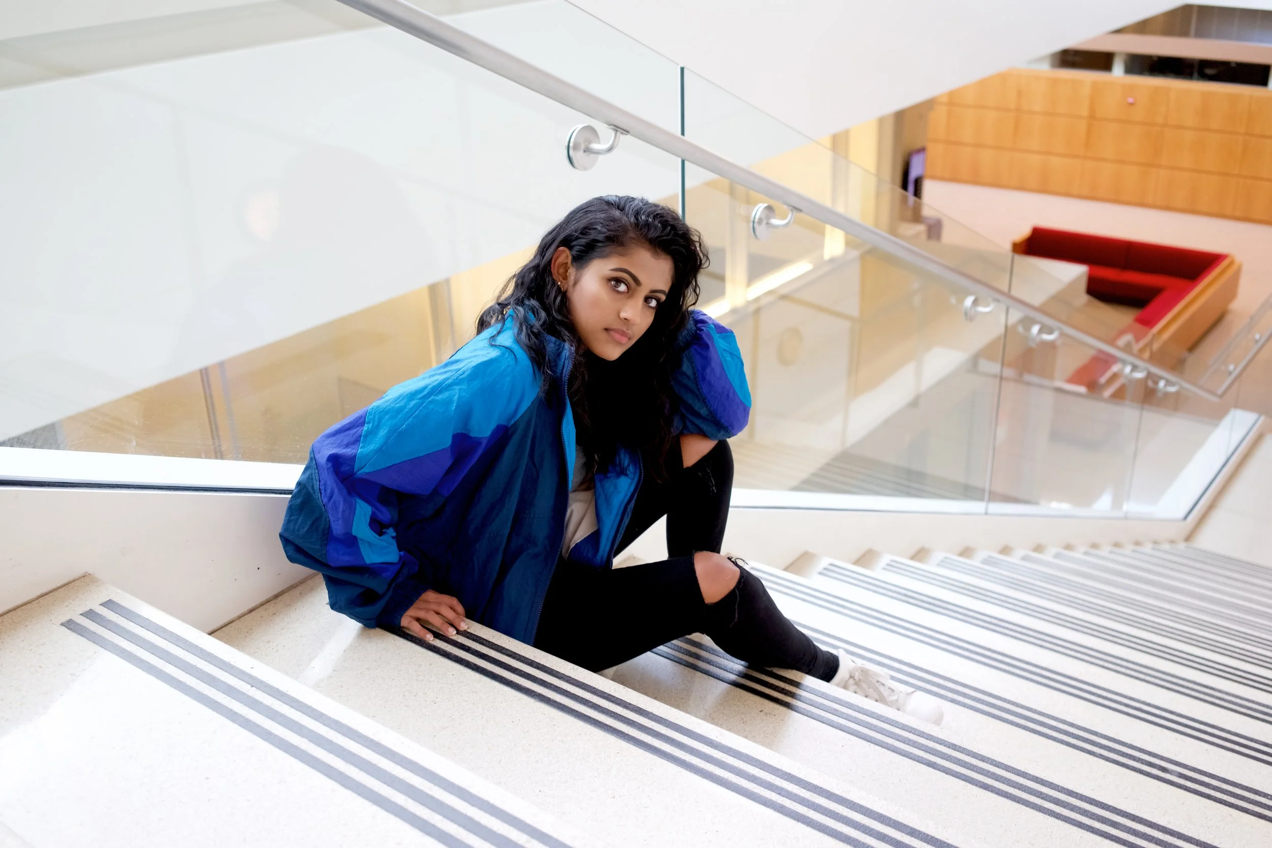 Here Yamini wears: a Reebok Jacket thrifted from Ragstock, a grey top from Nordstrom, jeans from Topshop, Adidas Stan Smiths, and a belt from Brandy Melville.