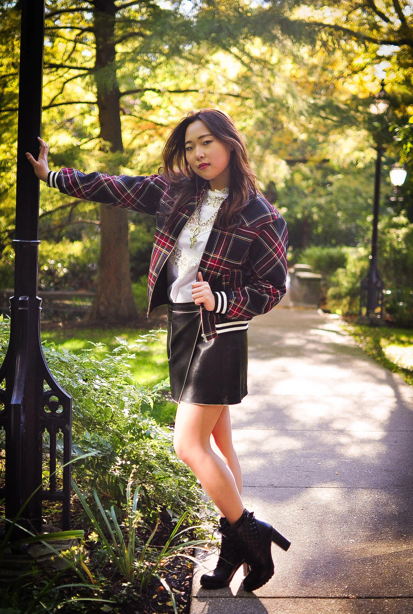 For this look, I’m wearing a tartan bomber jacket draped over a white lace blouse, coupled with a leather skirt, all from Korea and chunky boots from Guess.