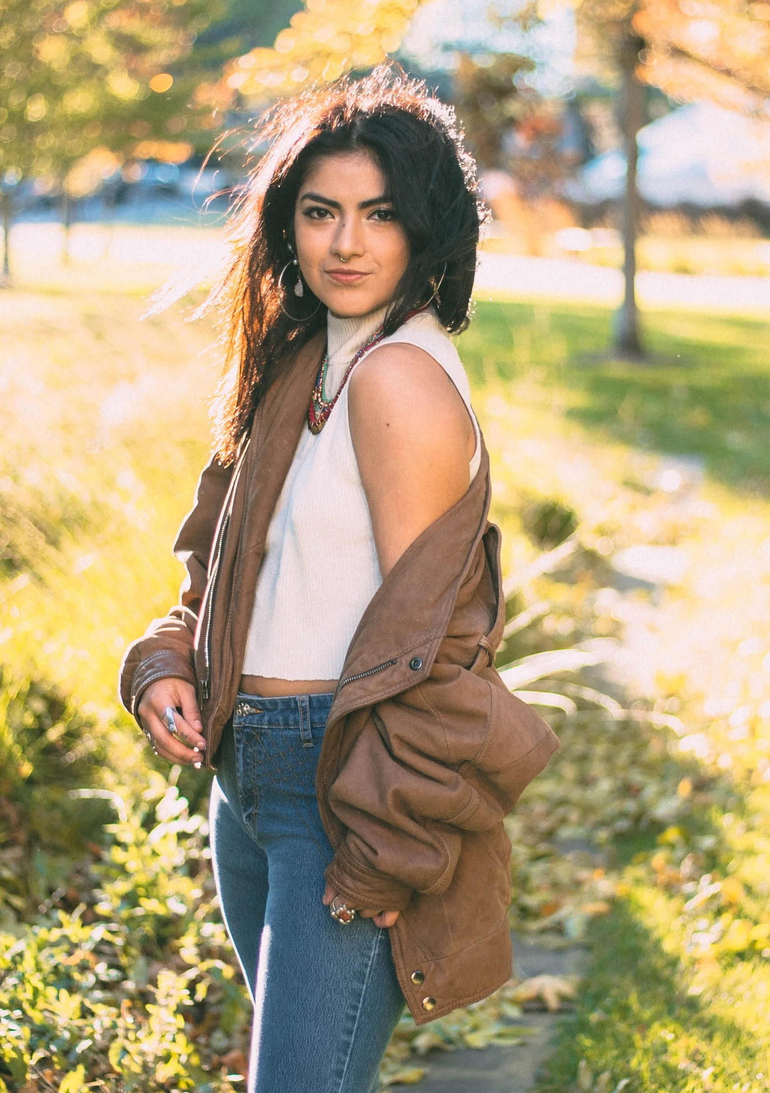 I’m wearing a Village Discount thrifted sleeveless cream turtleneck that I cropped, flare high-waisted jeans, and brown leather loafers (Unique find, brand: Naturalizer)