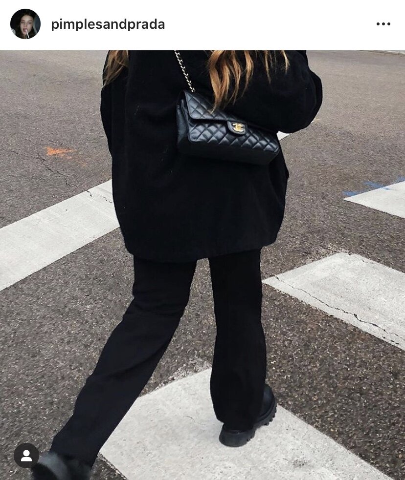 Potter crossing the street in an all black outfit, punctuated by a classic Chanel double flap. Image Via