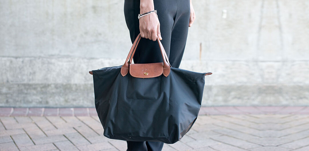 The durable yet stylish Longchamp Le Pliage in black. Image Via