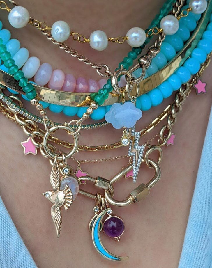 Featuring precious and semi-precious stones along with a healthy dose of bright enamel, this #neckmess sets a perfect example. Image via