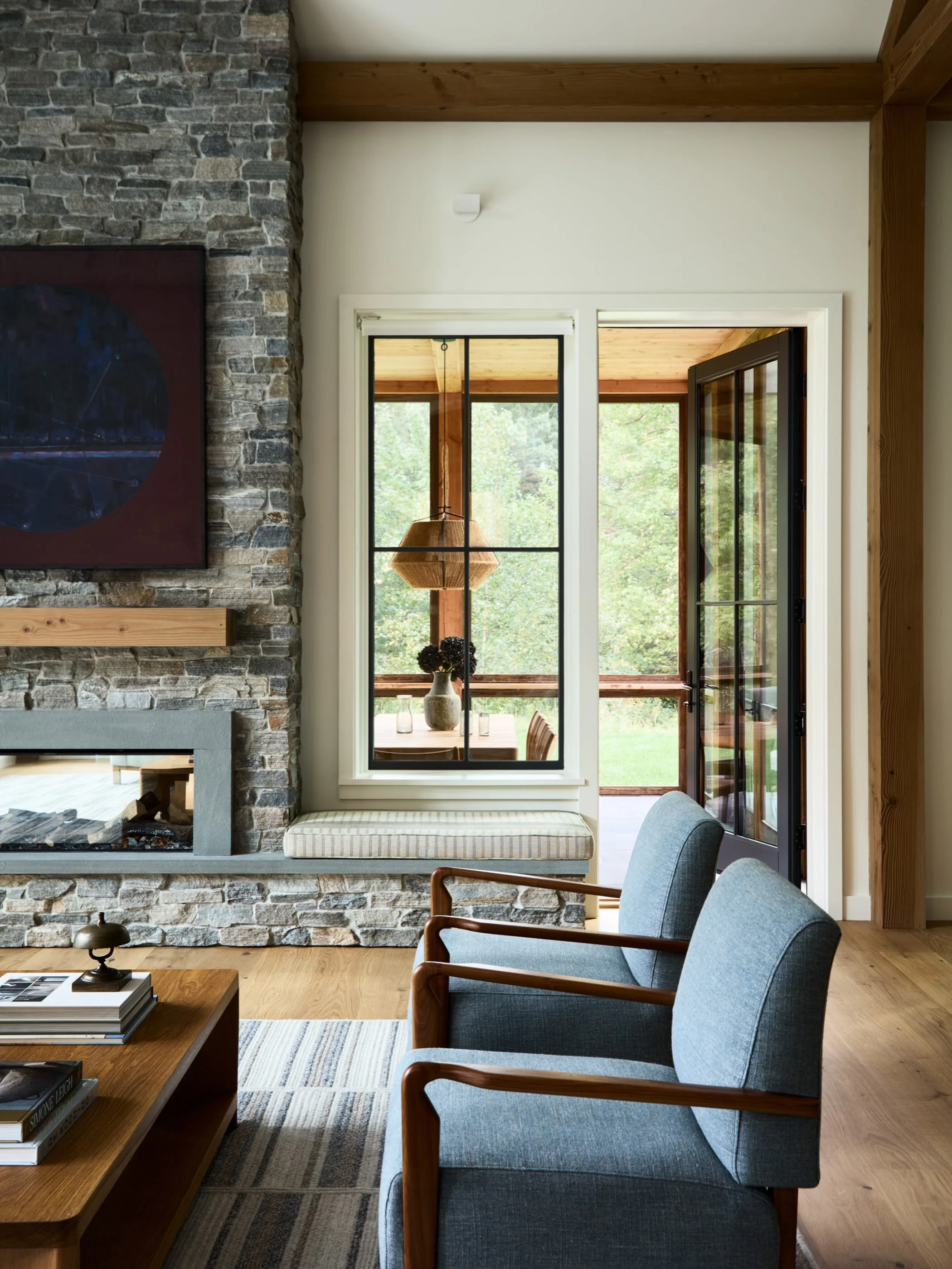 The views from the living to the screened in porch at our Concord project. Surrounded by nature. 
We kept the palette natural, calm and full of texture. A custom rug from our own line added pattern and warmth. #thayerdesignstudio #thoughtformsbuilder