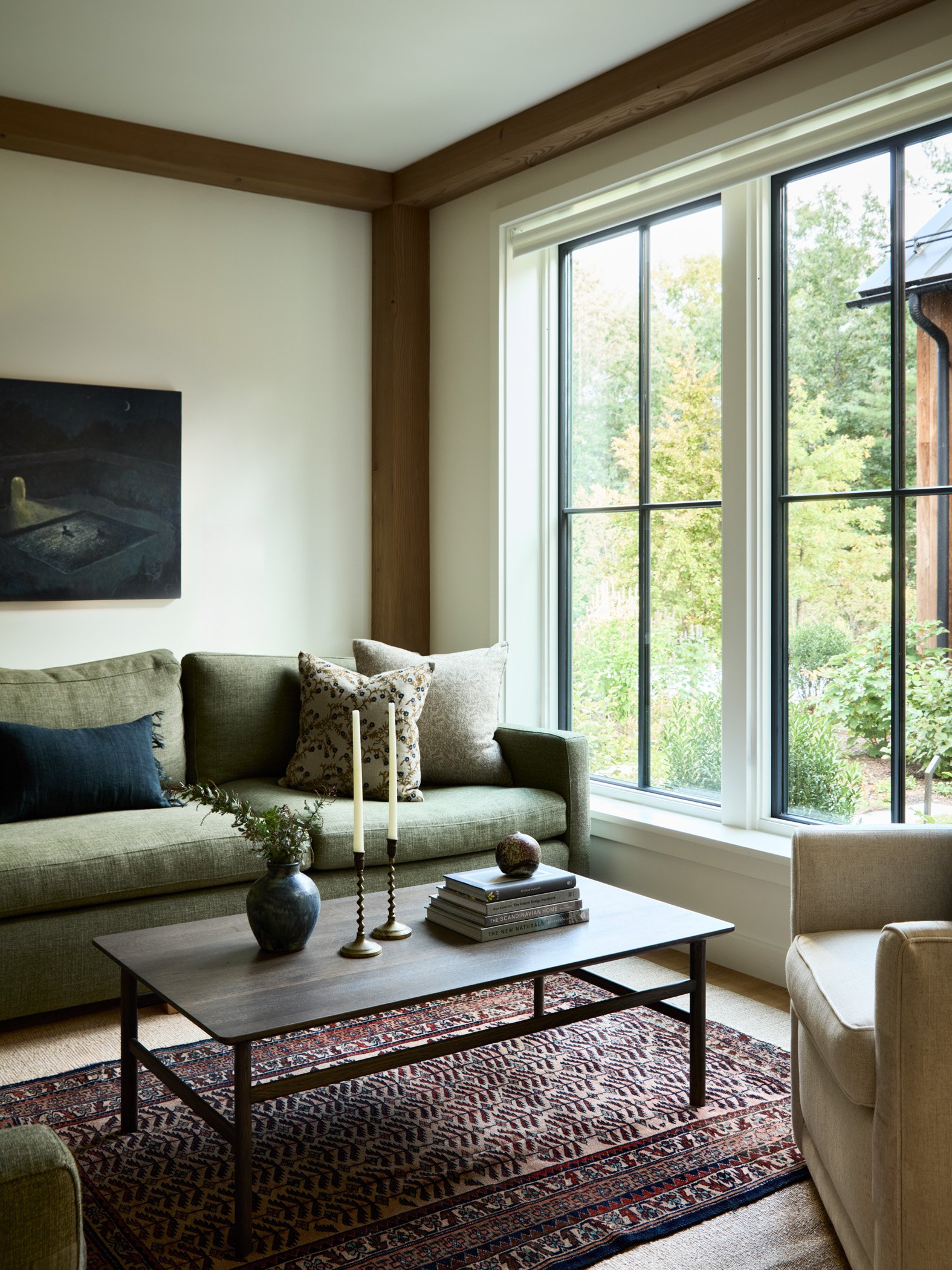 Den interior designed by Thayer Design Studio with layered furnishings and a custom rug