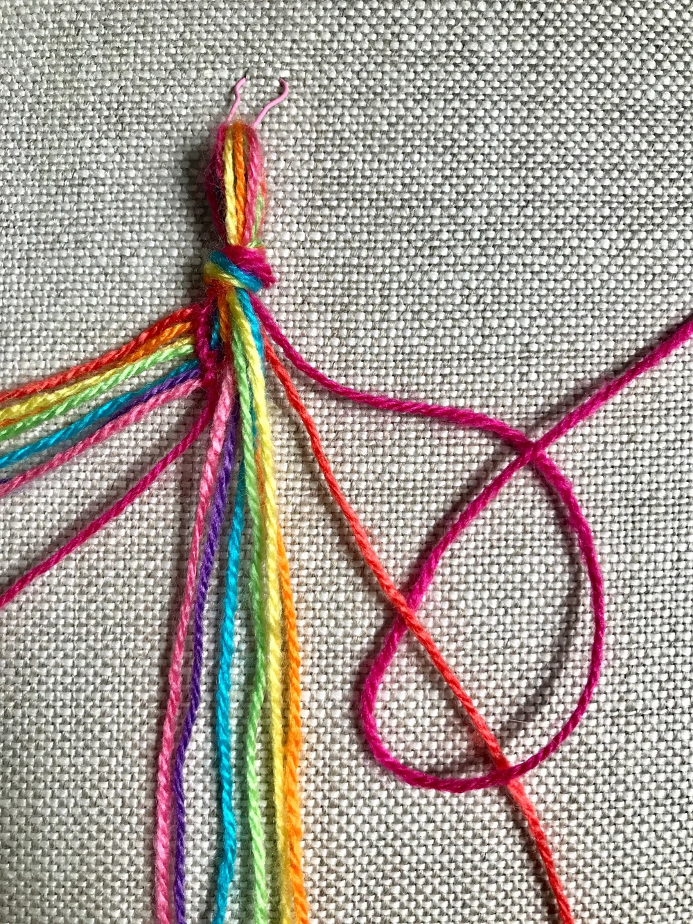 9. Then bring the working thread UNDER the other thread and up through the loop created with the backward “4” shape. Pull to secure the knot at the top of the work, then repeat the knot a second time to complete the  backward knot  (again, this knot is actually made up of  two  knots).