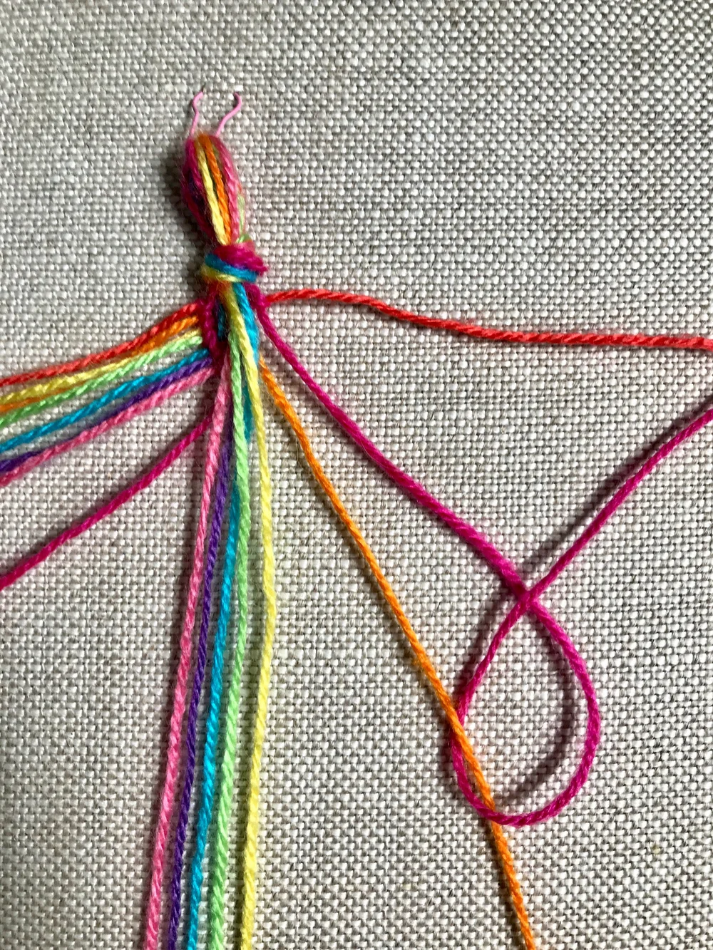 11. Again, bring the working thread UNDER the other and up through the loop created. Repeat the knot to finish the  backward knot .