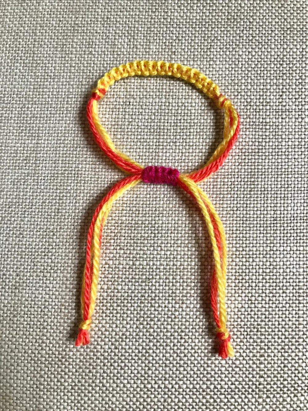 21. Tie a knot at the end of each bracelet tail. To tighten the bracelet, pull on the tail ends. To expand the bracelet, pull on the bracelet itself.