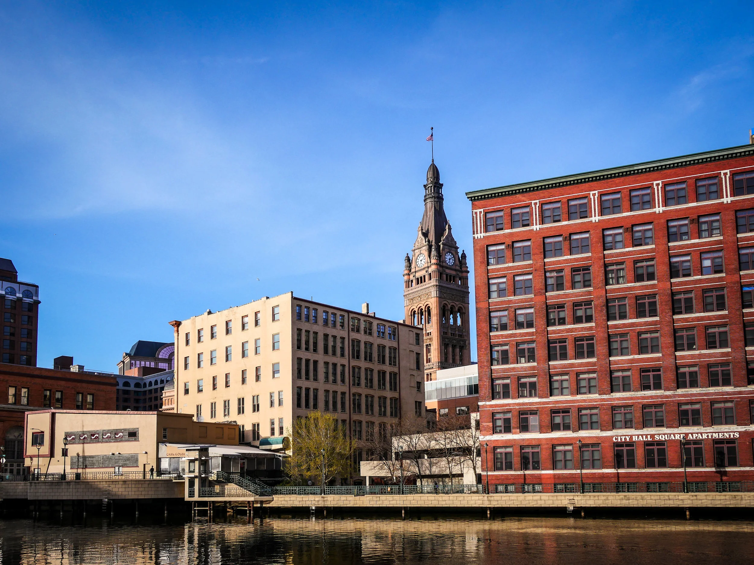 Clear blue skies provide a backdrop to brick buildings and the City Hall Clock Tower. 