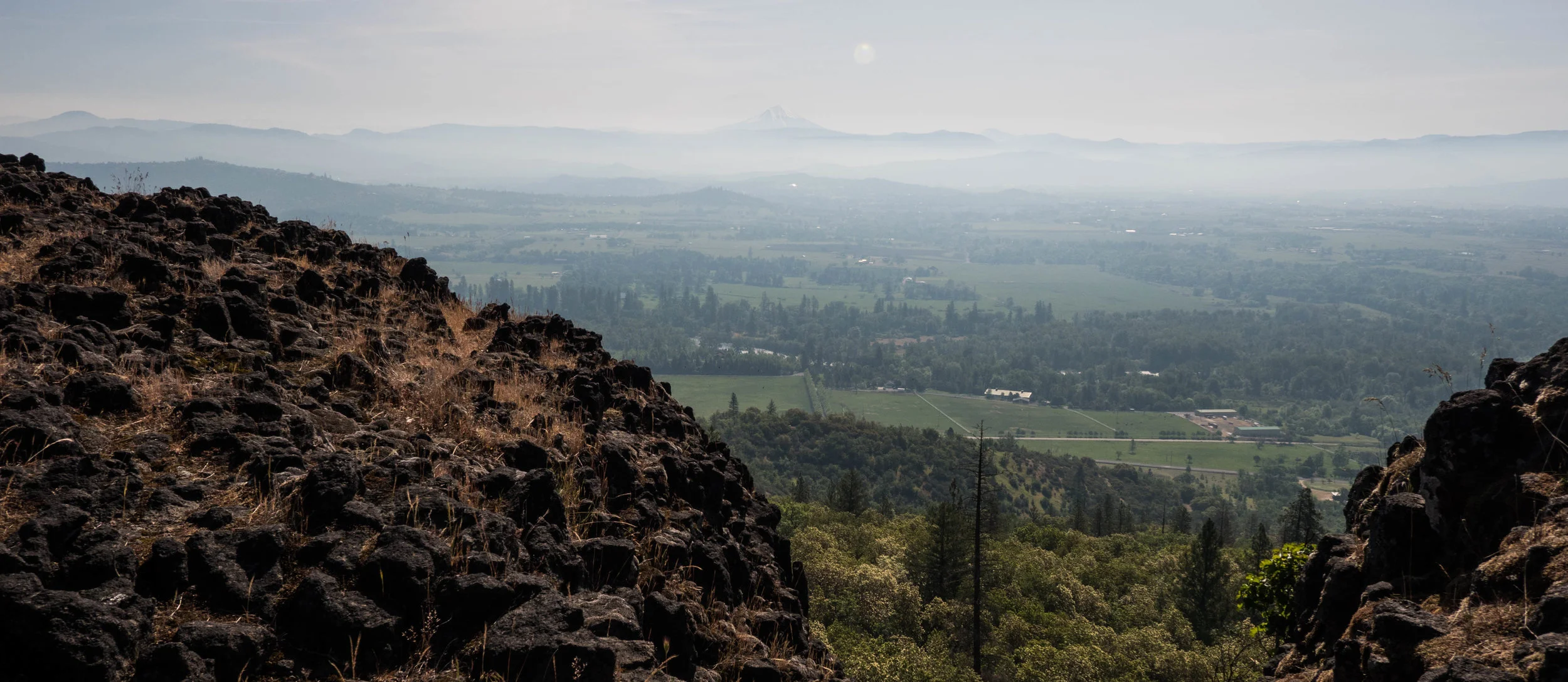 Remnants of lava rock on top of the mesa. The communities of the Rogue Valley below.