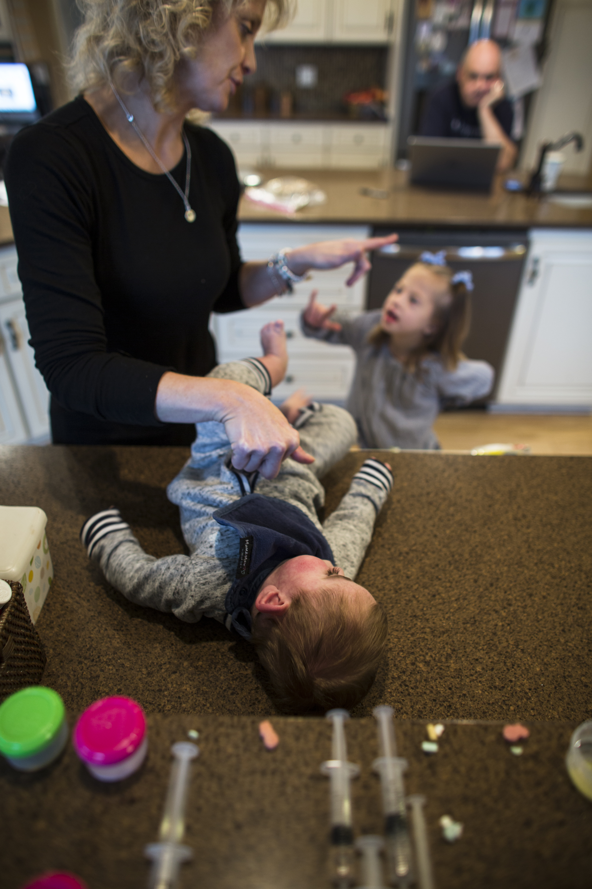  Brittany injects medicine into Wyatt's stomach through his G-tube while signing "I love you" to her adopted daughter Everleigh (6). Nov. 18, 2017 