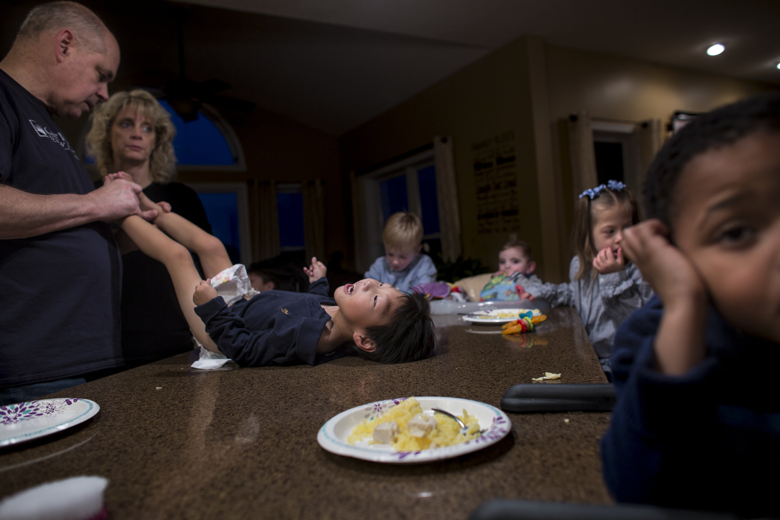  Barry changes Graham's diaper during a family dinner. The kitchen island is the center for all happenings of the Jencik family, from dinner, to diapers changes and minor medical procedures. Nov. 18, 2017 