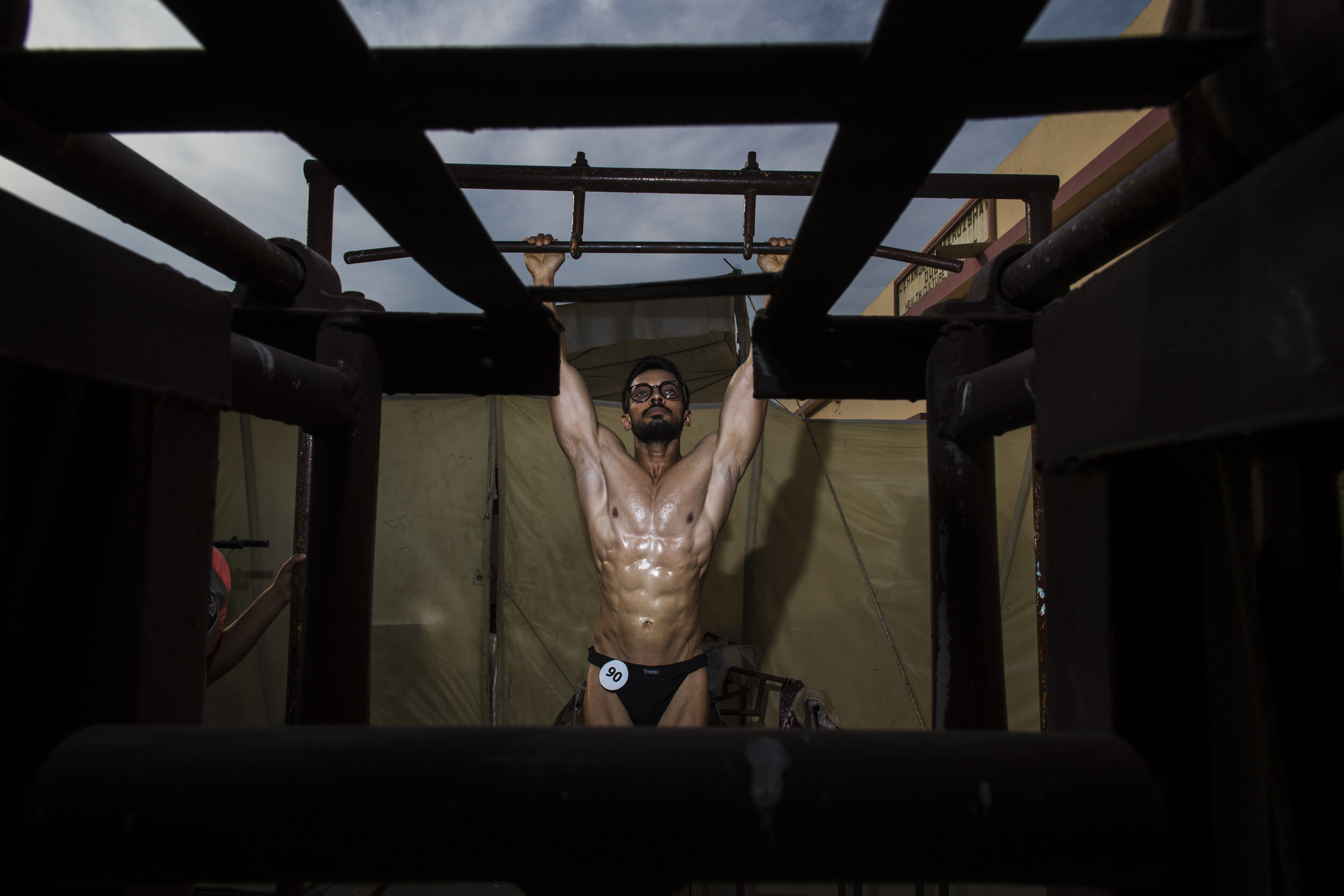  A competitor hangs from a pull-up bar.  