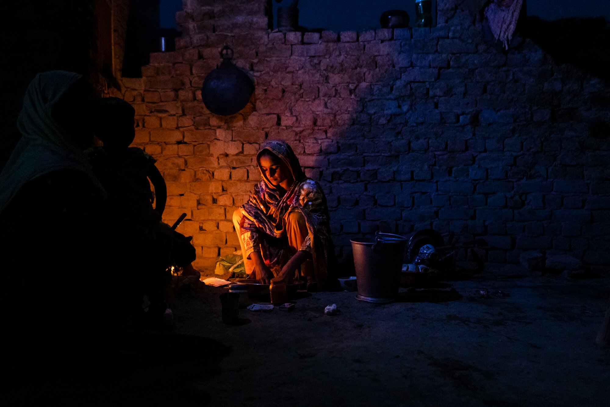  Parveen Seelro prepares food for her family, accompanied by her mother and daughter.  