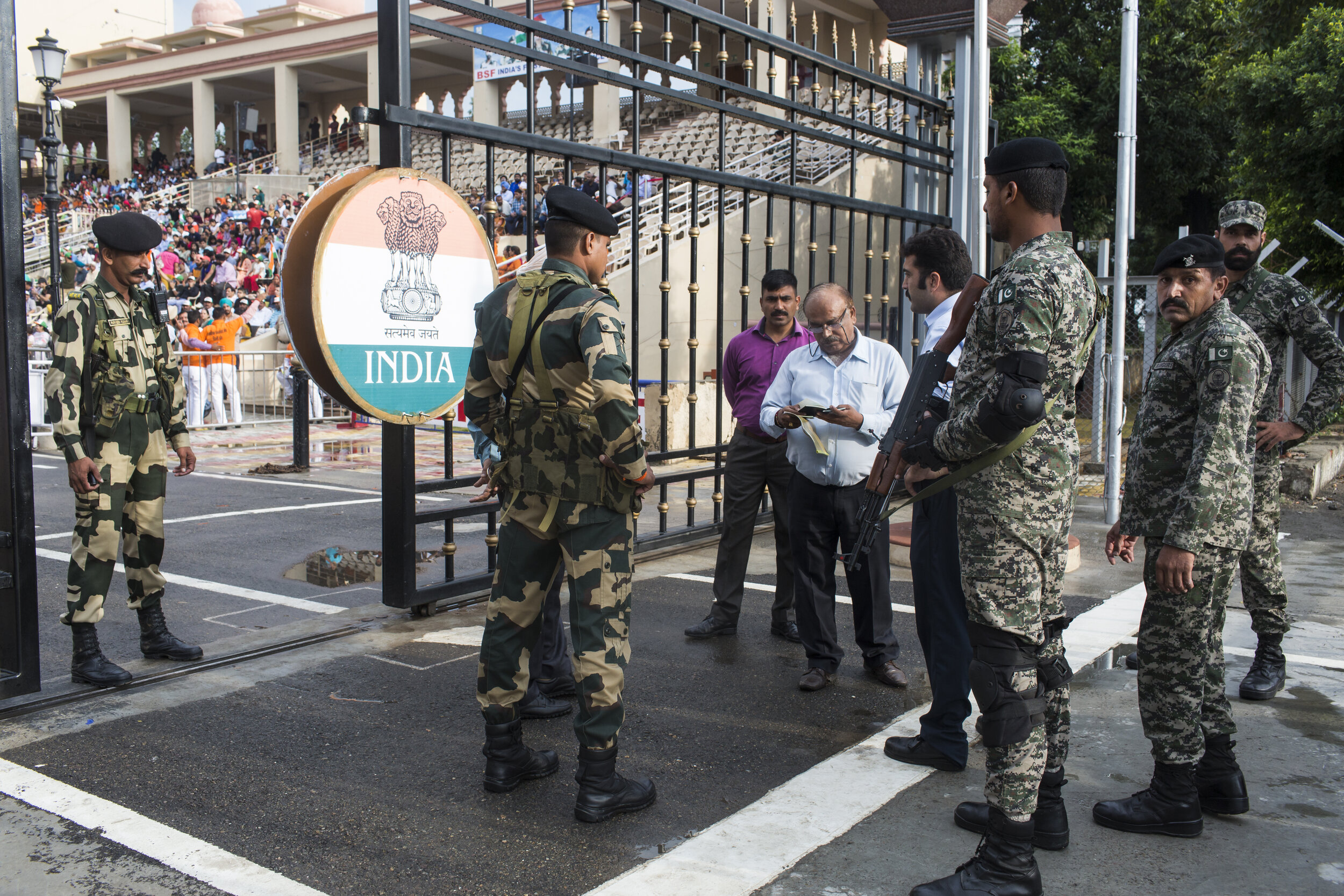  An official checks the passport of a Pakistani citizen crossing  into India at the Wagah-Attari border. 