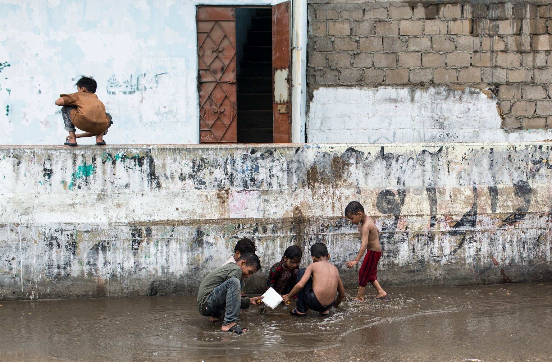  Children play in stagnant water.  