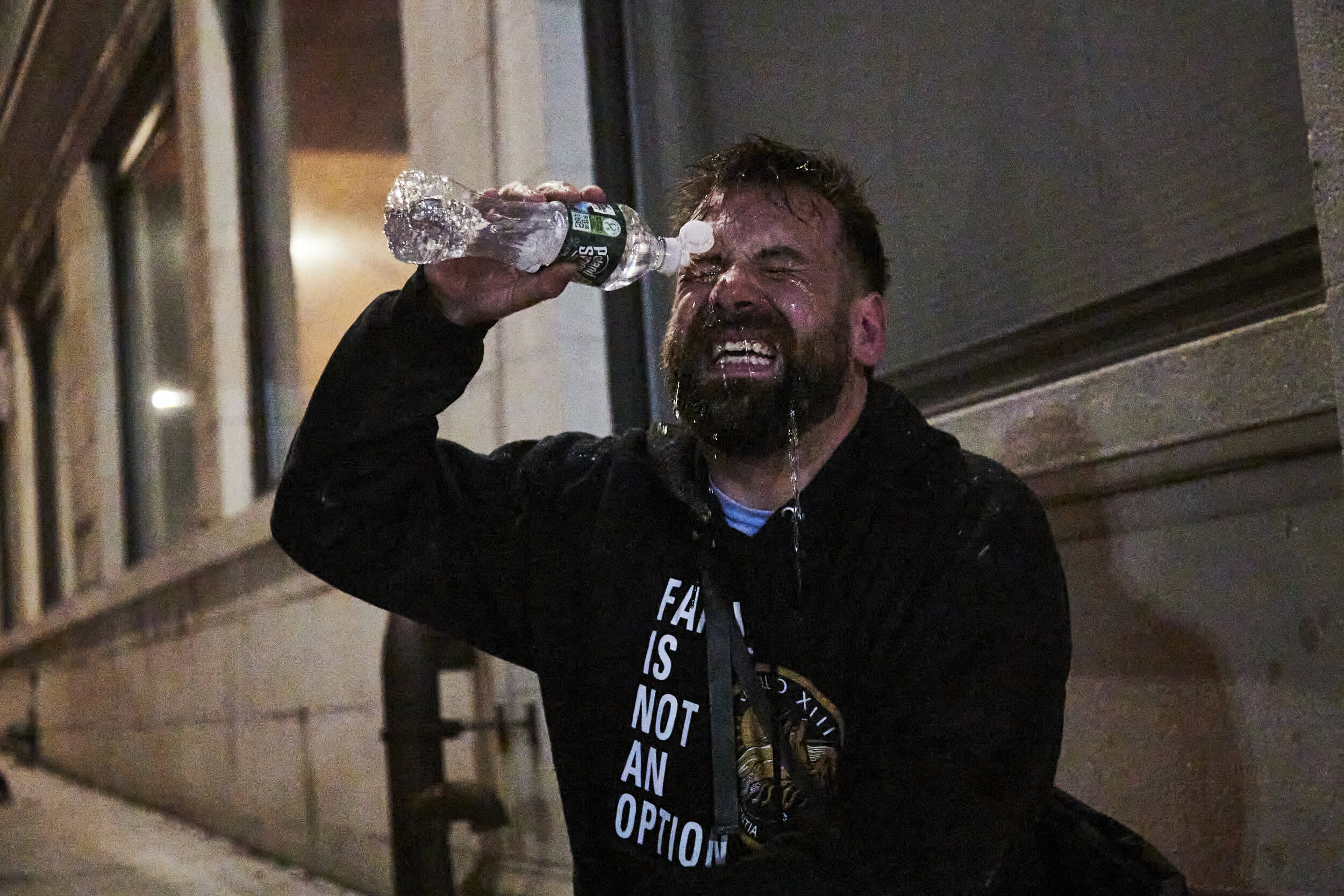  ROCHESTER, N.Y. - Sept 5, 2020: A peaceful protestor washes tear gas from his eyes with a water bottle.  