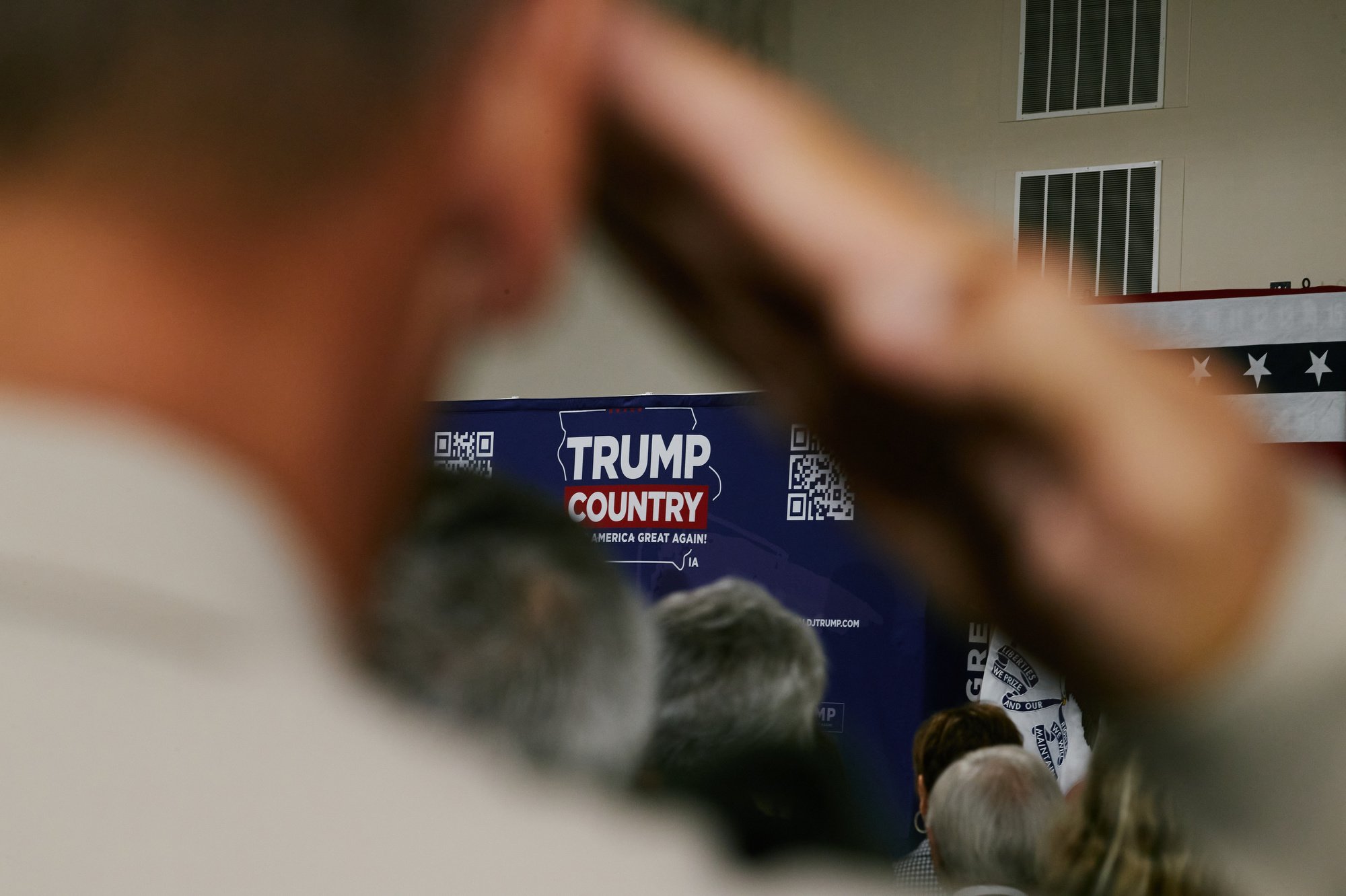  A supporter makes a salute during the National Anthem at the Team Trump Iowa Commit to Caucus Event at the Jackson County Fairgrounds in Maquoketa, IA on Sept. 20, 2023. (Mustafa Hussain for the New York Times) 