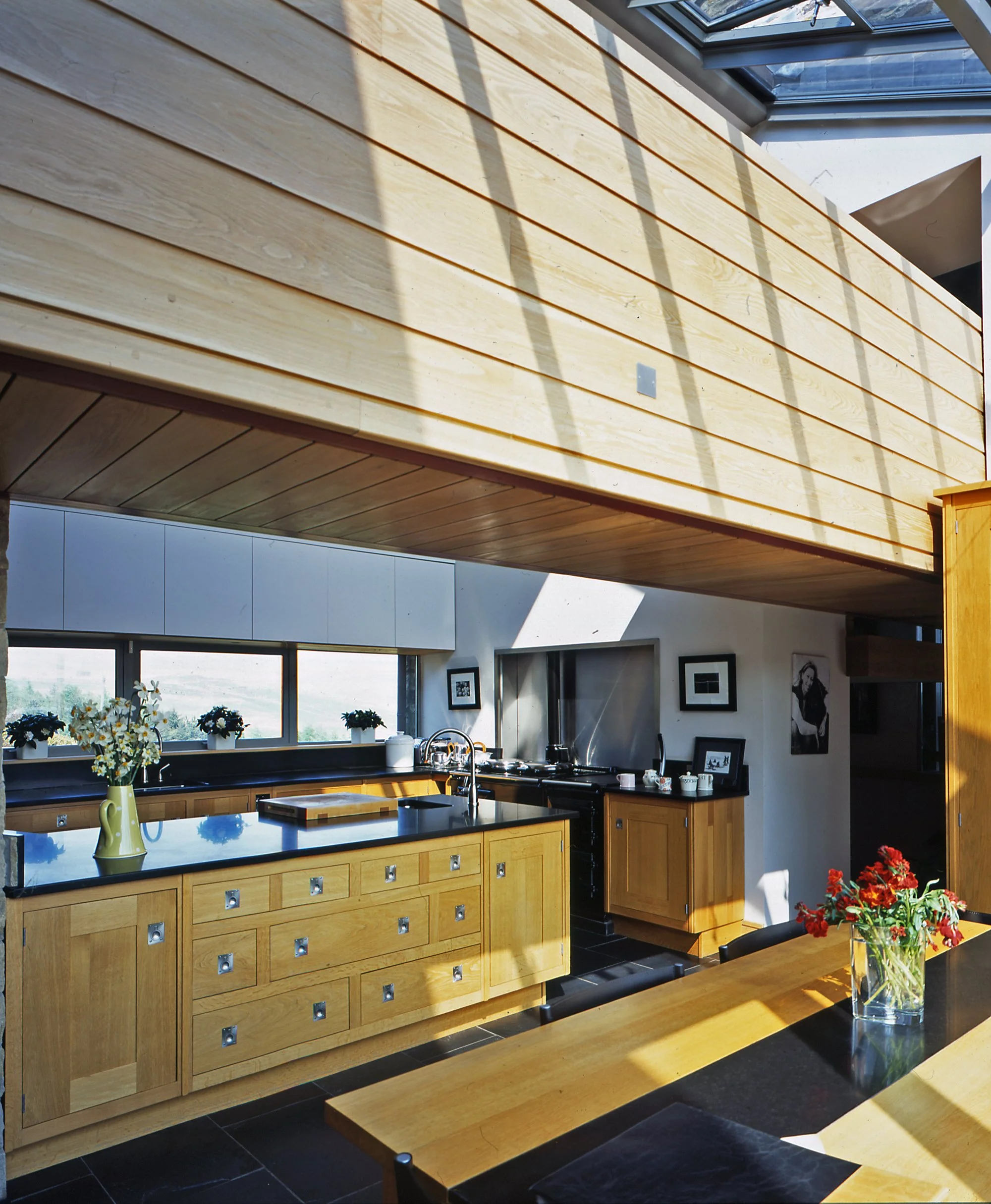 Contemporary kitchen interior with timber joinery and glazed link view at Cotes Farm Lancashire