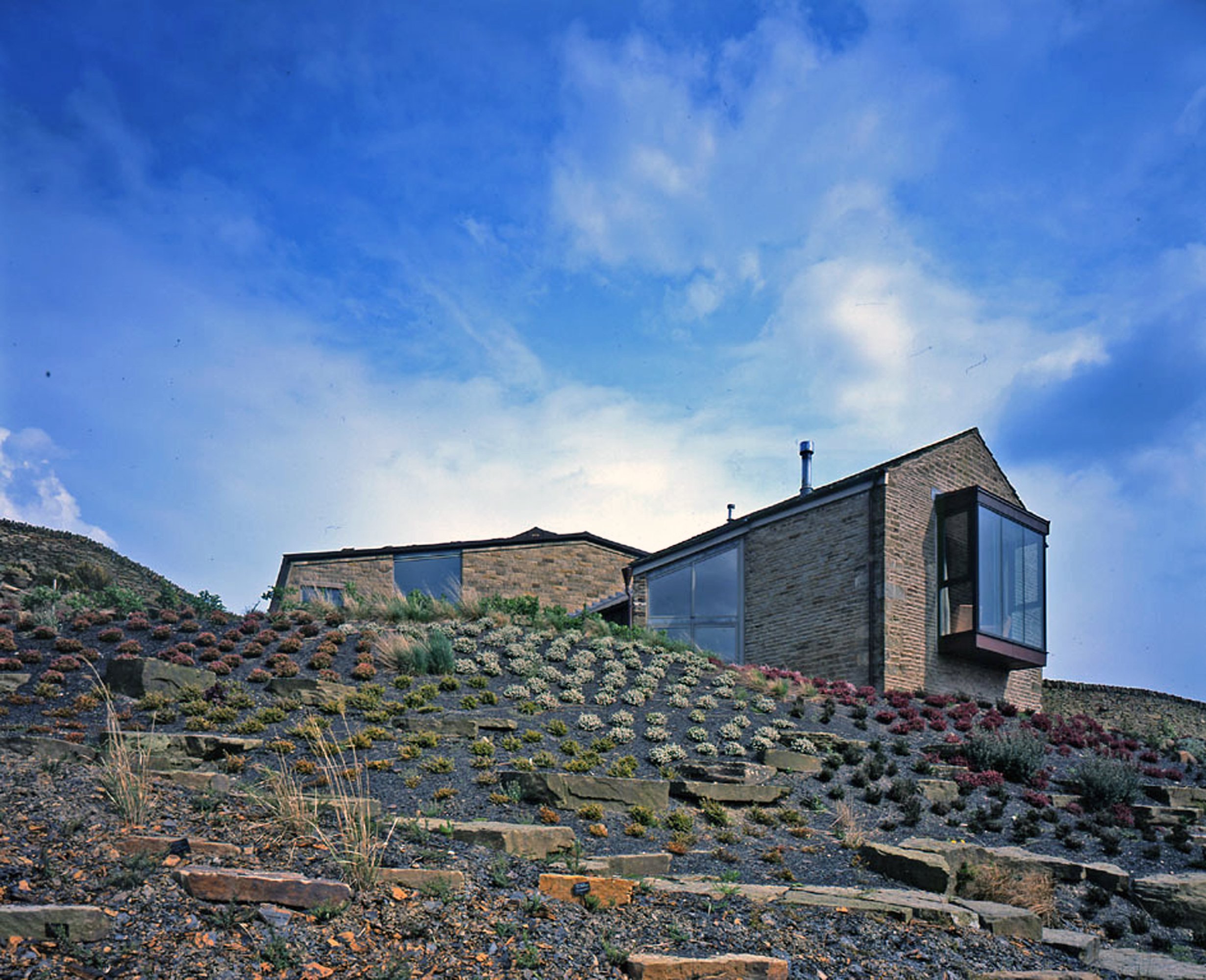Cotes Farm exterior gable showing copper mansard roof and split-faced millstone grit walls in Lancashire