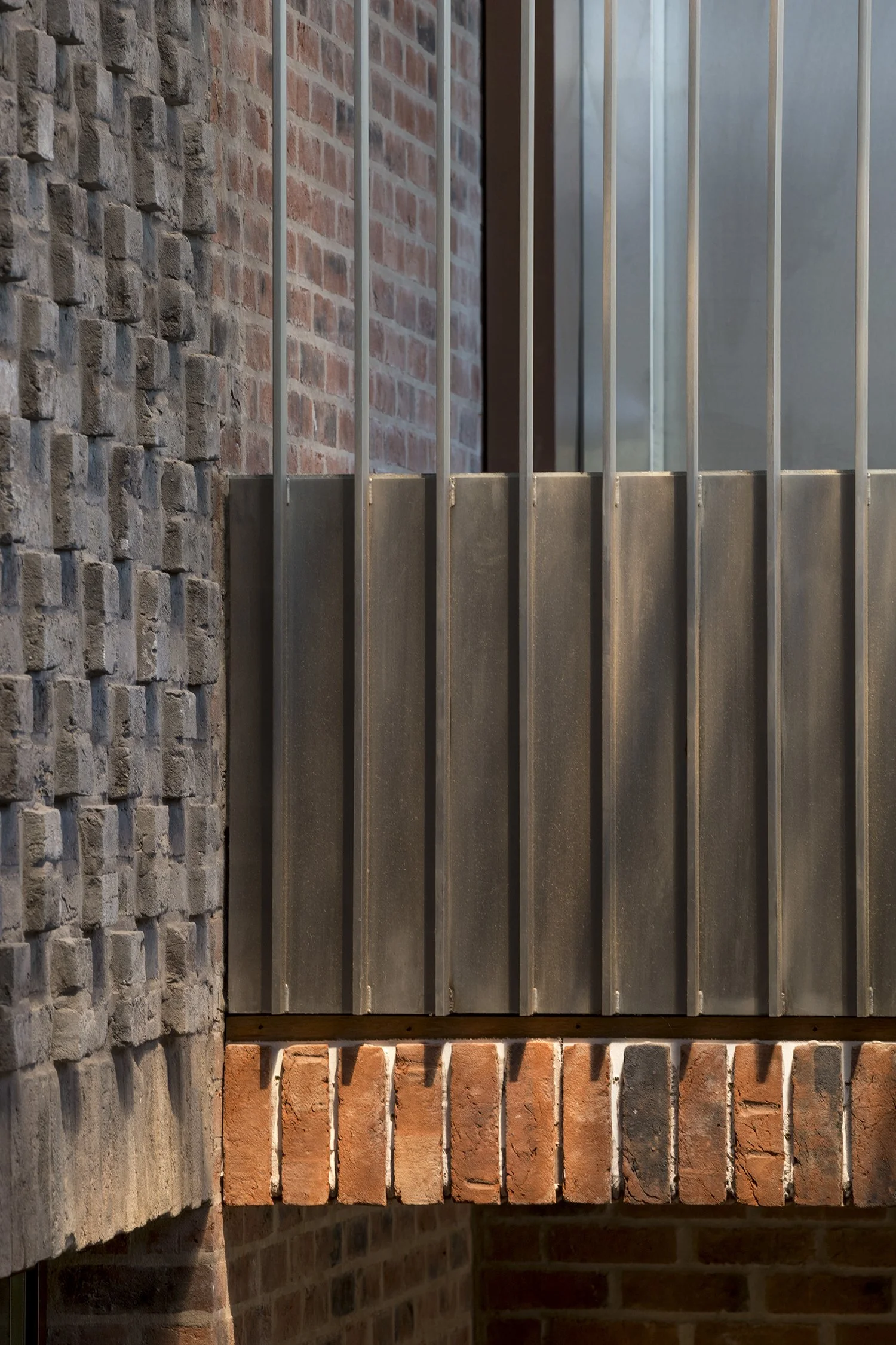 Various types of bricks and stone arranged on a building exterior.