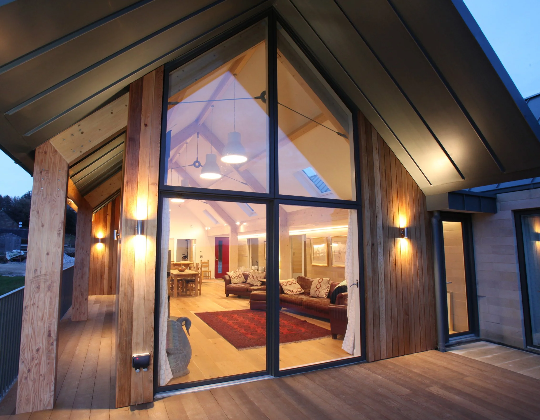 Overhanging timber roof structure and covered walkway wrapping around the southern elevation of Alton Nether Farm.