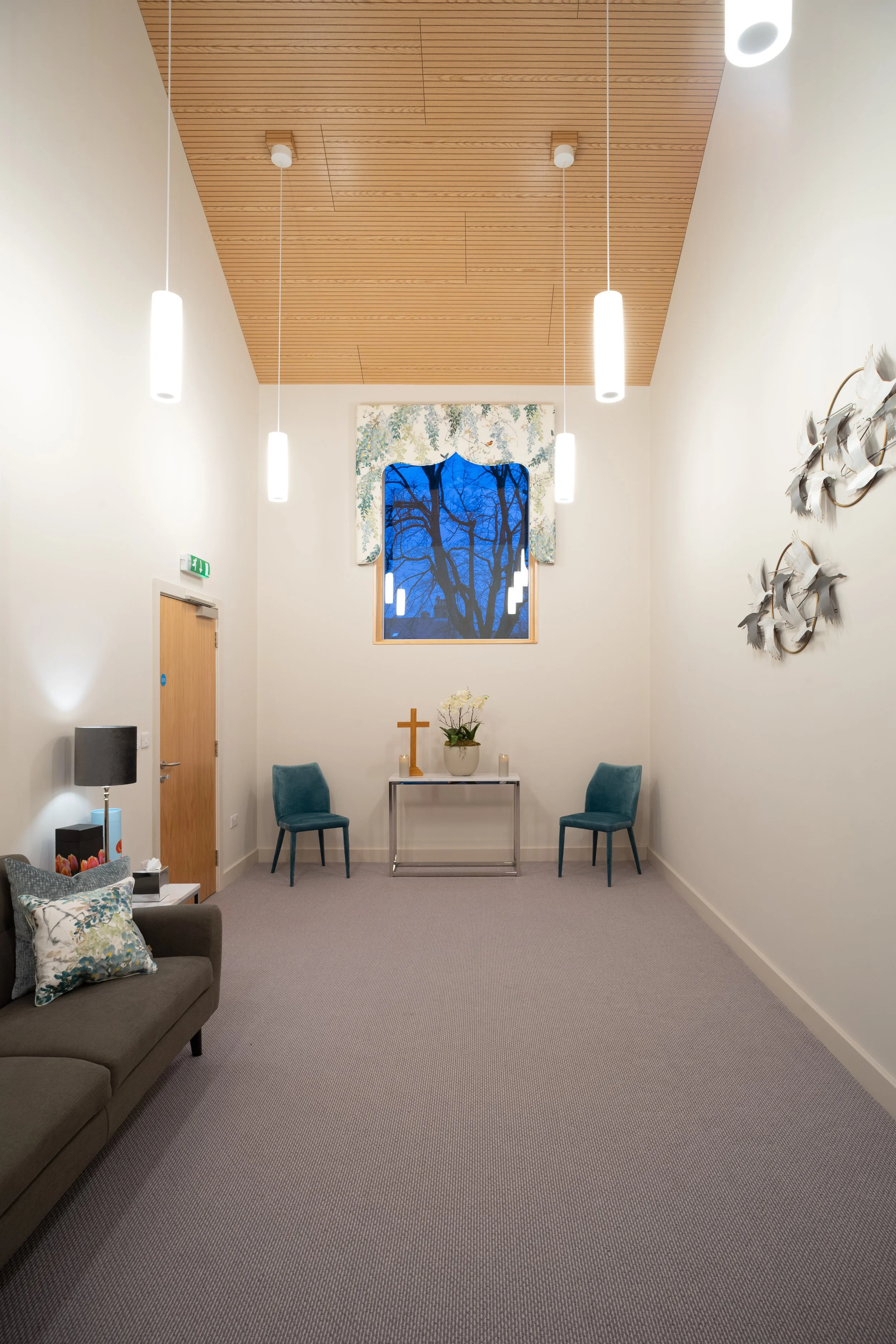 Spiritual chapel of rest interior at Belfield House Buxton featuring high-level window looking toward historic church