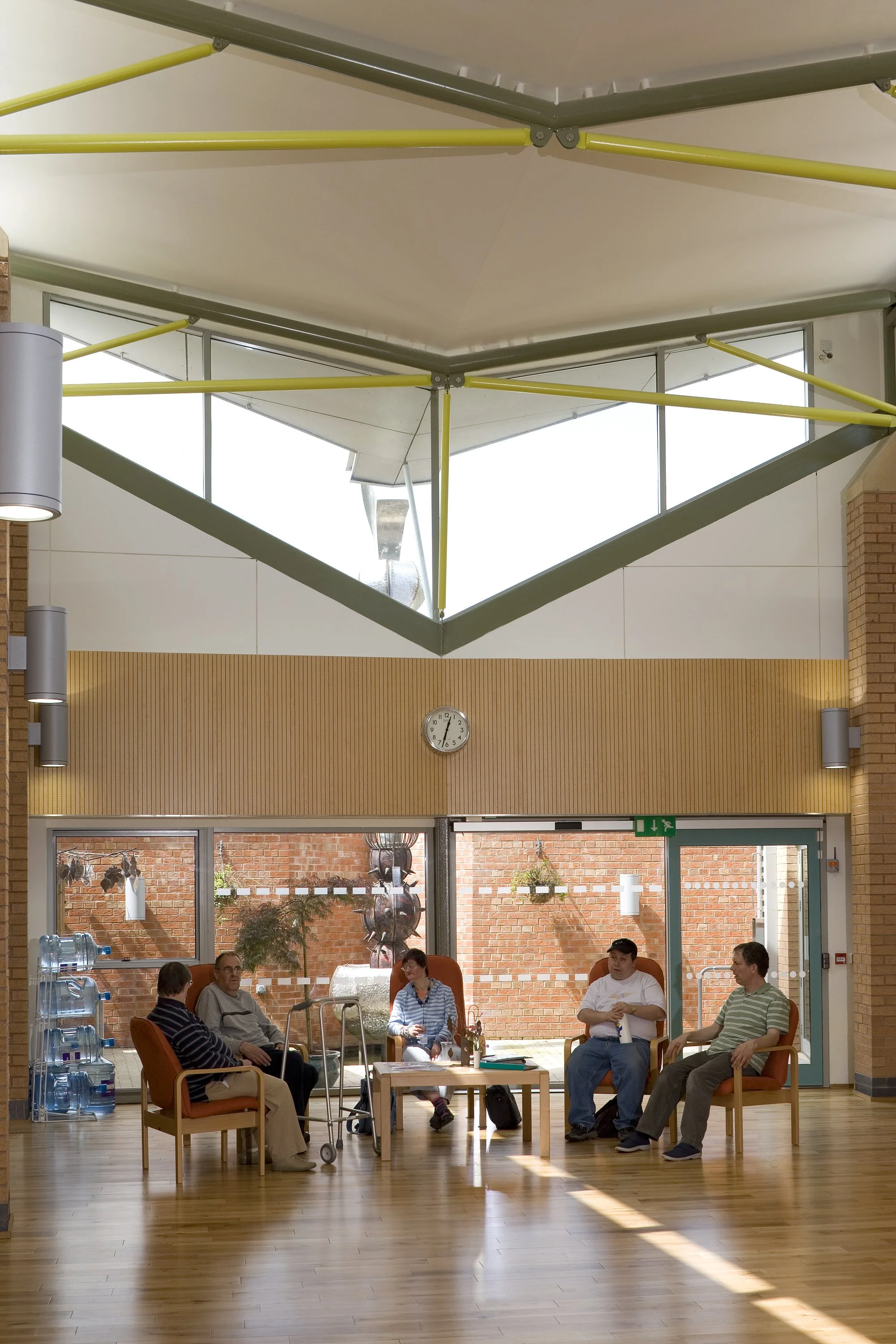 Bright central tapering atrium at Brackenfield SEND Centre with natural timber accents and wide, barrier-free corridors.