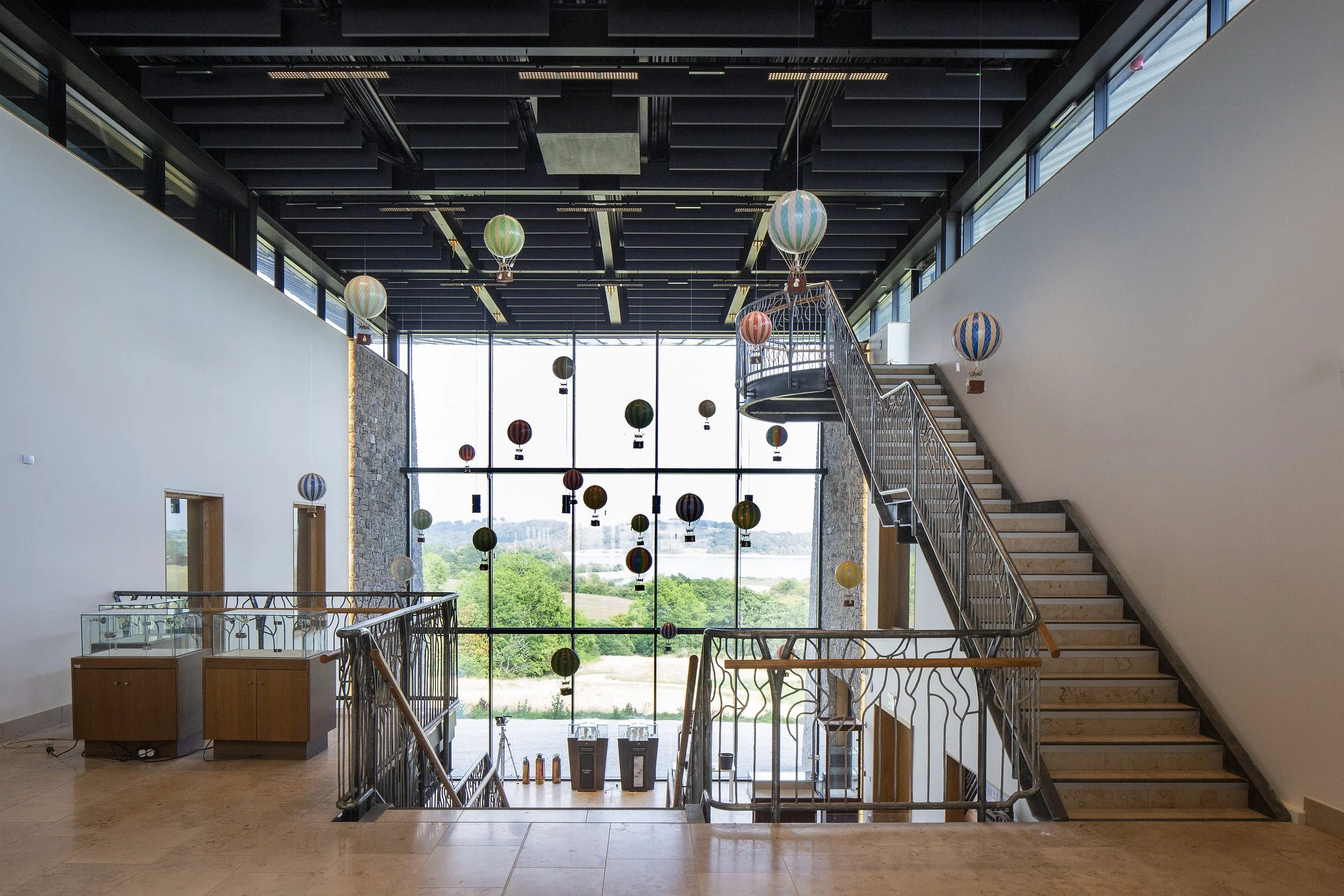 Triple-height glass atrium entrance with a feature staircase and natural light at Waters View.