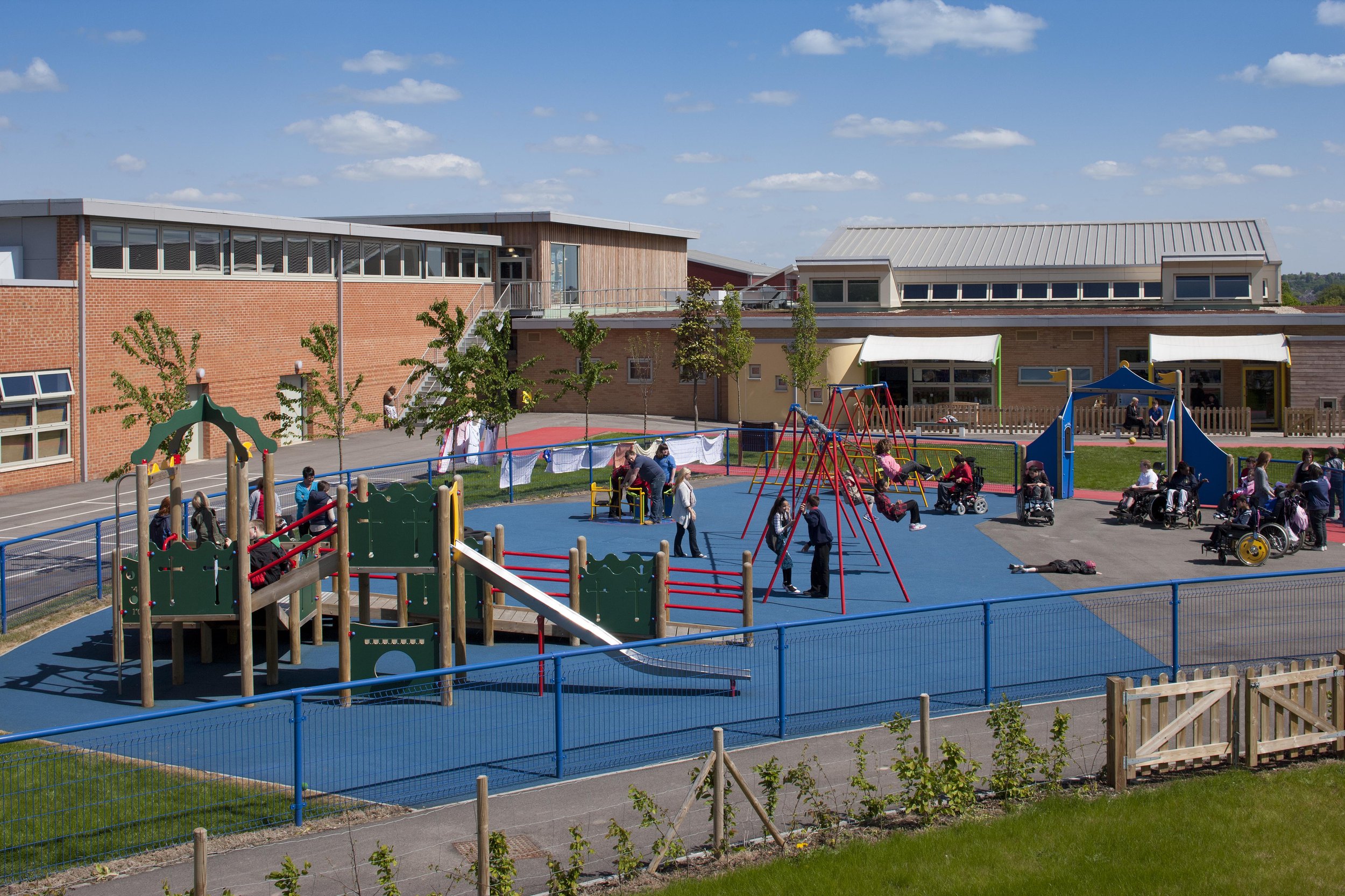 Landscaped internal sensory courtyard at Oak Field School surrounded by top-lit corridors and green sedum roof elements.