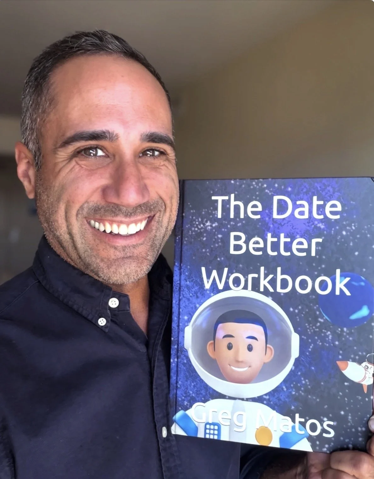Smiling man holding a book titled "The Date Better Workbook" by Greg Matos, with an animated astronaut on the cover.