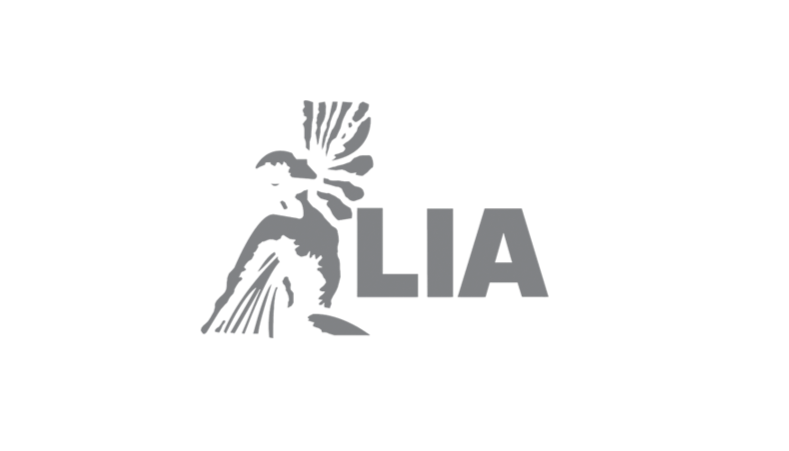 A logo featuring a Native American headdress and the words 'WE LIA' in bold letters.